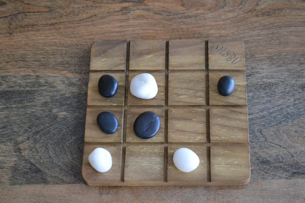 A single SHOBU board, showing a series of stones from both players -- none of which are safe from enemy attack.
