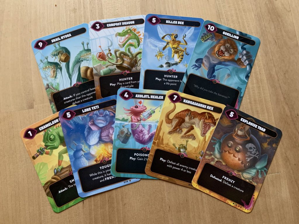A picture of several cards from the game laid out on a table, showcasing the vibrant colors and dramatic posing of each creature card.