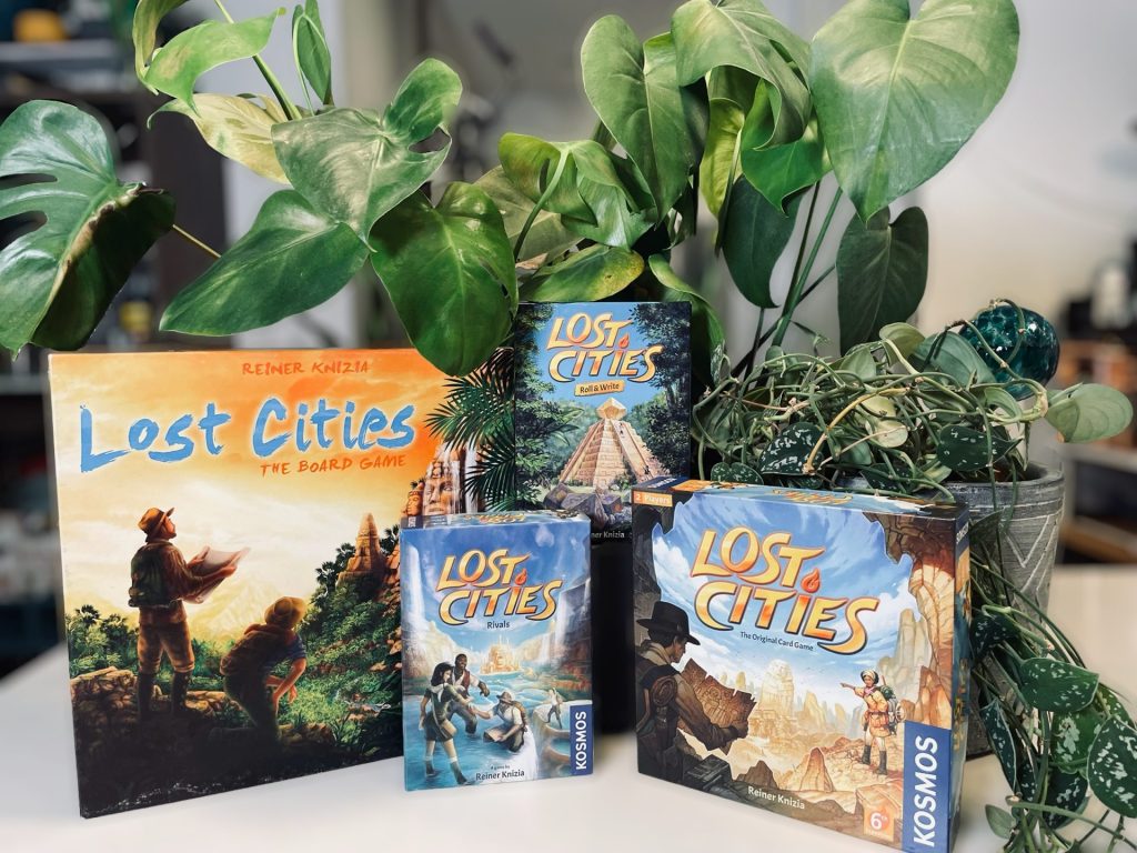 A picture of the Lost Cities games tastefully arranged amongst potted plants.
