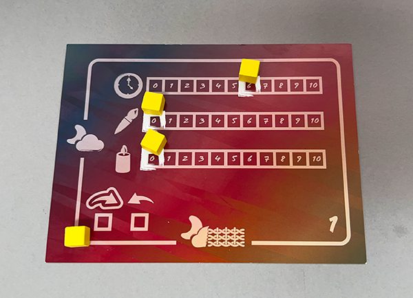 A player card with cubes set near their starting spaces.