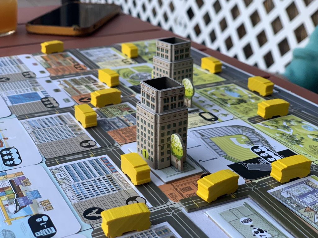Skyscrapers and trolleys on a player board.
