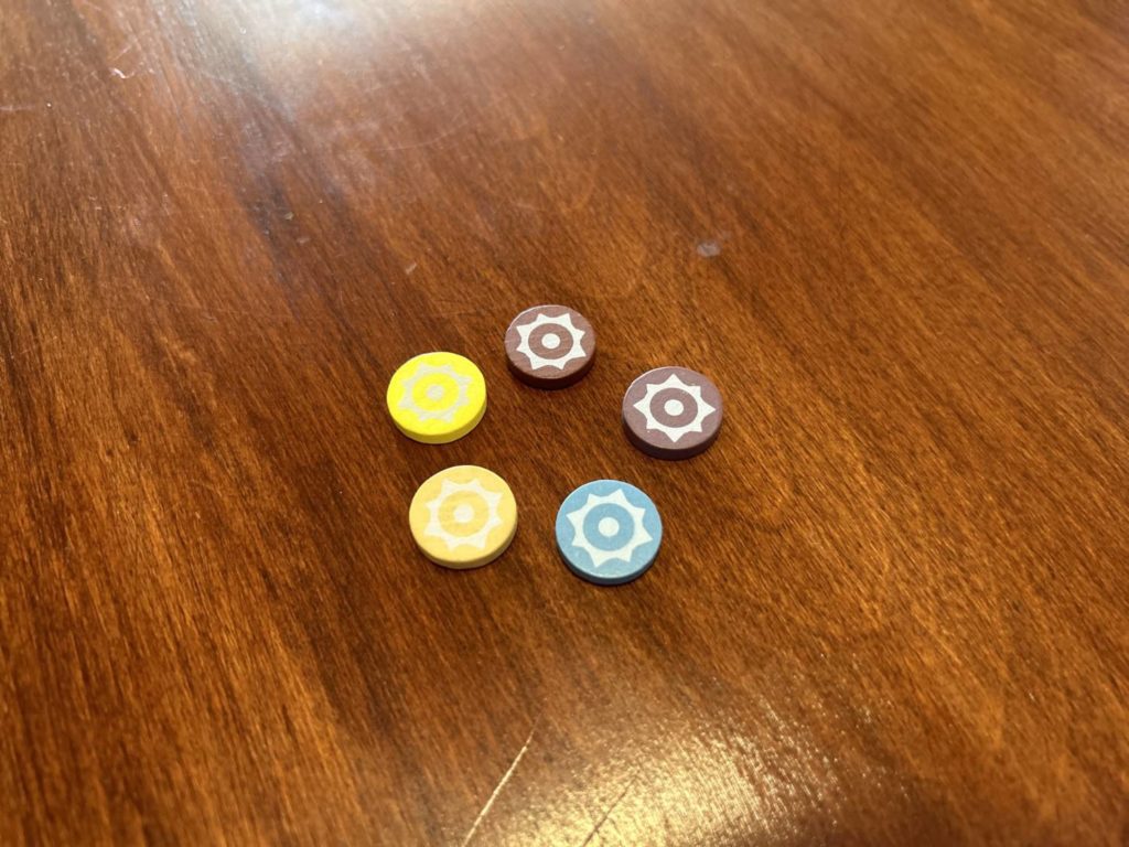 The five player pieces. Two are near-identical shades of brown, and two are near-identical shades of yellow.