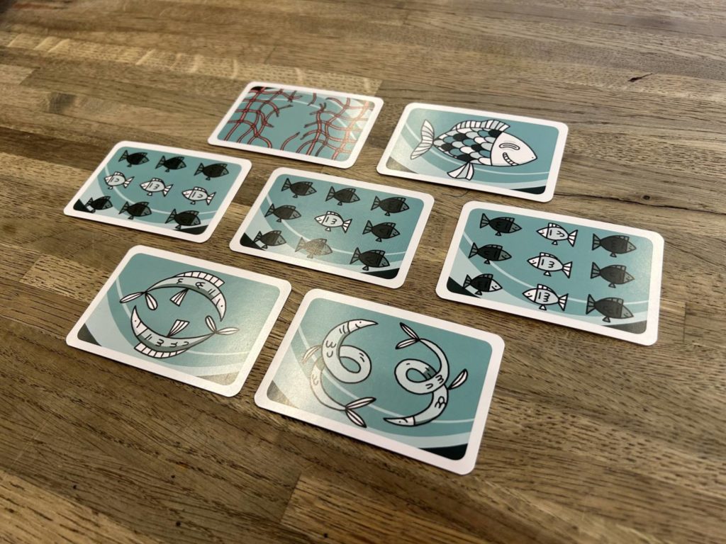 The seven different cards players may have available to them on a turn. Each features a charming illustration of one or more fish.