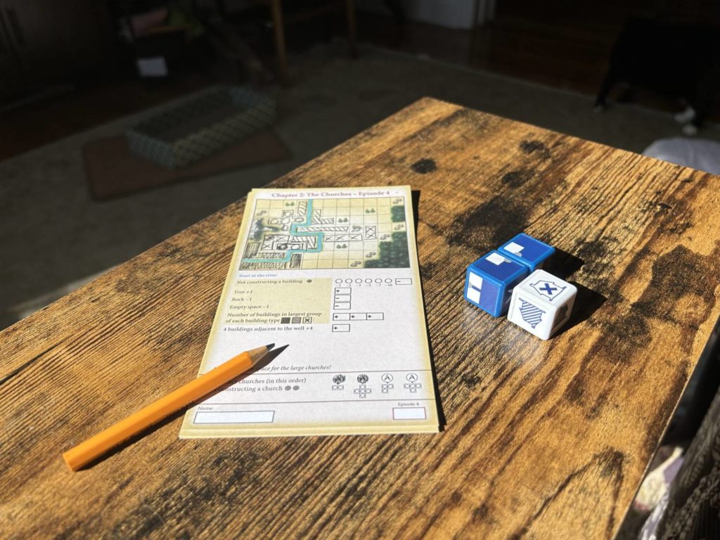 A player sheet on a table along with the three dice.