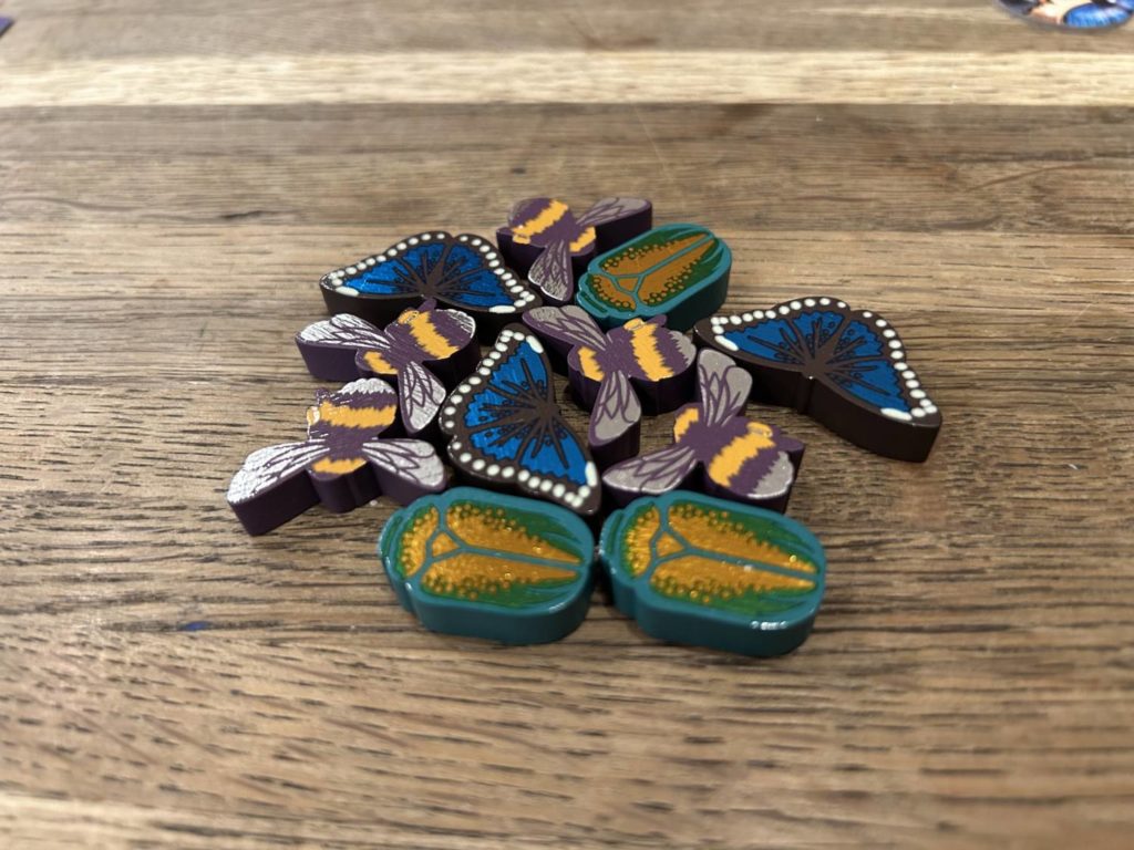 Wooden bug tokens, with foiled reflective material on the top.