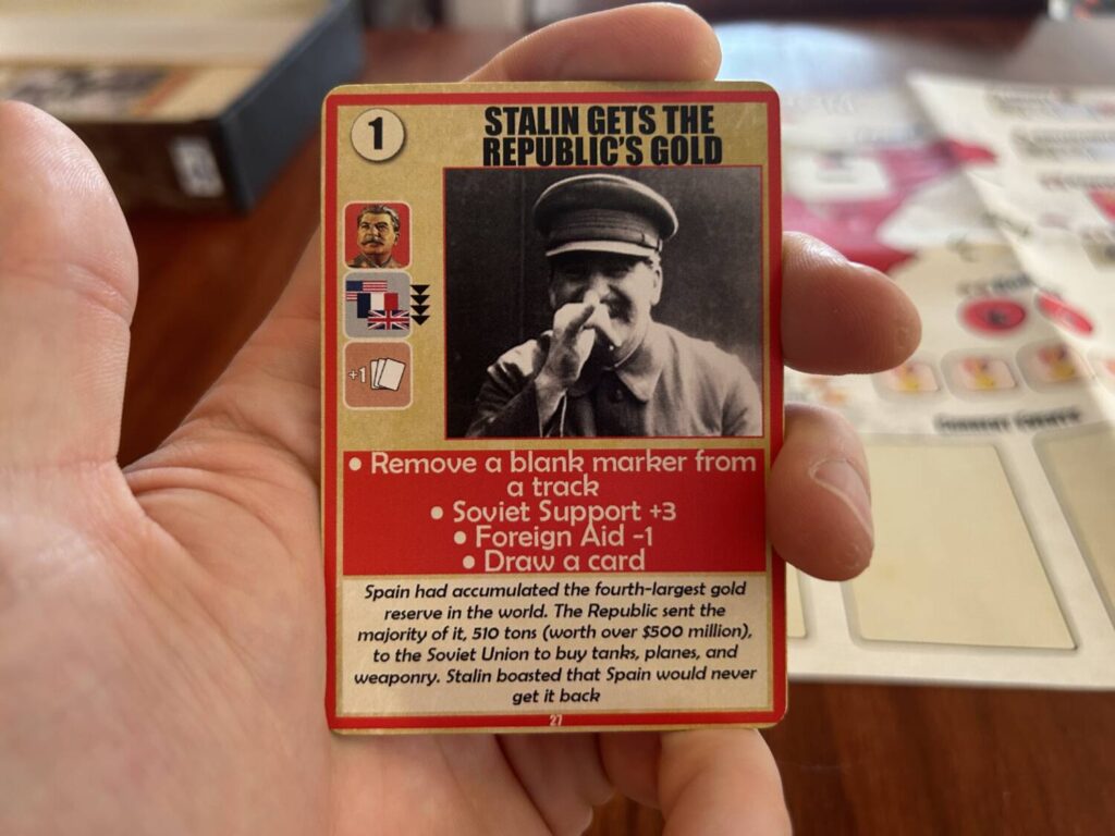 A player card, called "Stalin Gets the Republic's Gold." In the upper left corner is the Action Point value of the card. Below that are three icons, which have an impact if the card is added to your tableau. Below that is a box listing the effects of the card if used for its event, and some historical flavor text.