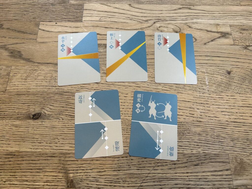 The cards for the game, laid out on a table. The graphic design, made up of various triangles, is striking.