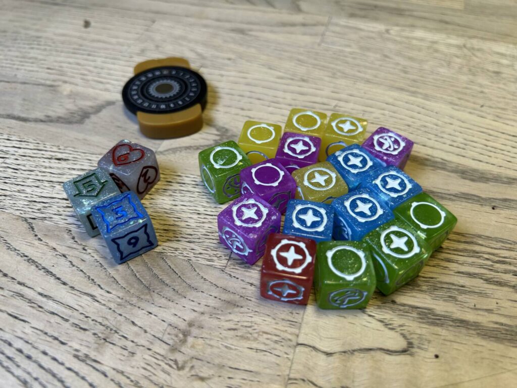 The full set of components for 20 Strong: a magnetized poker chip, three special dice, and seventeen attack dice of various colors.