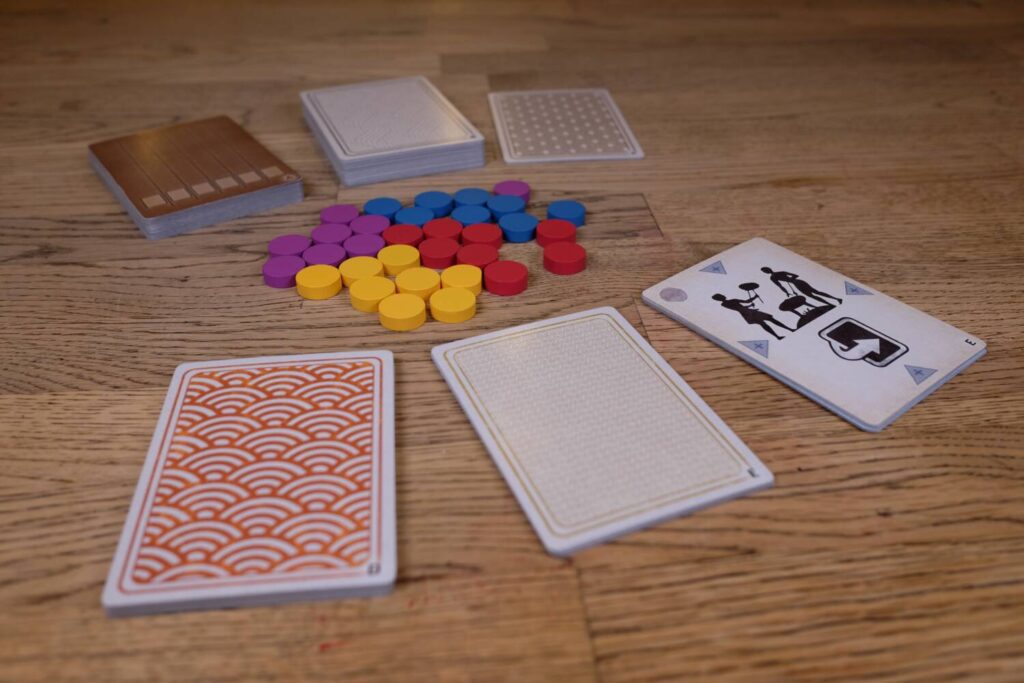The components are six decks of cards and thirty-two wooden discs.