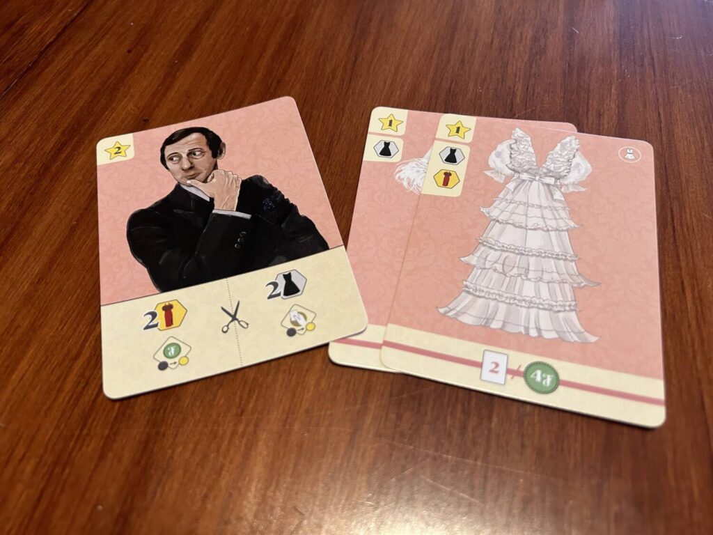 A designer with some of the outfit cards, meant to highlight the icons on the outfits and how they correspond to the icons on the designer's card.