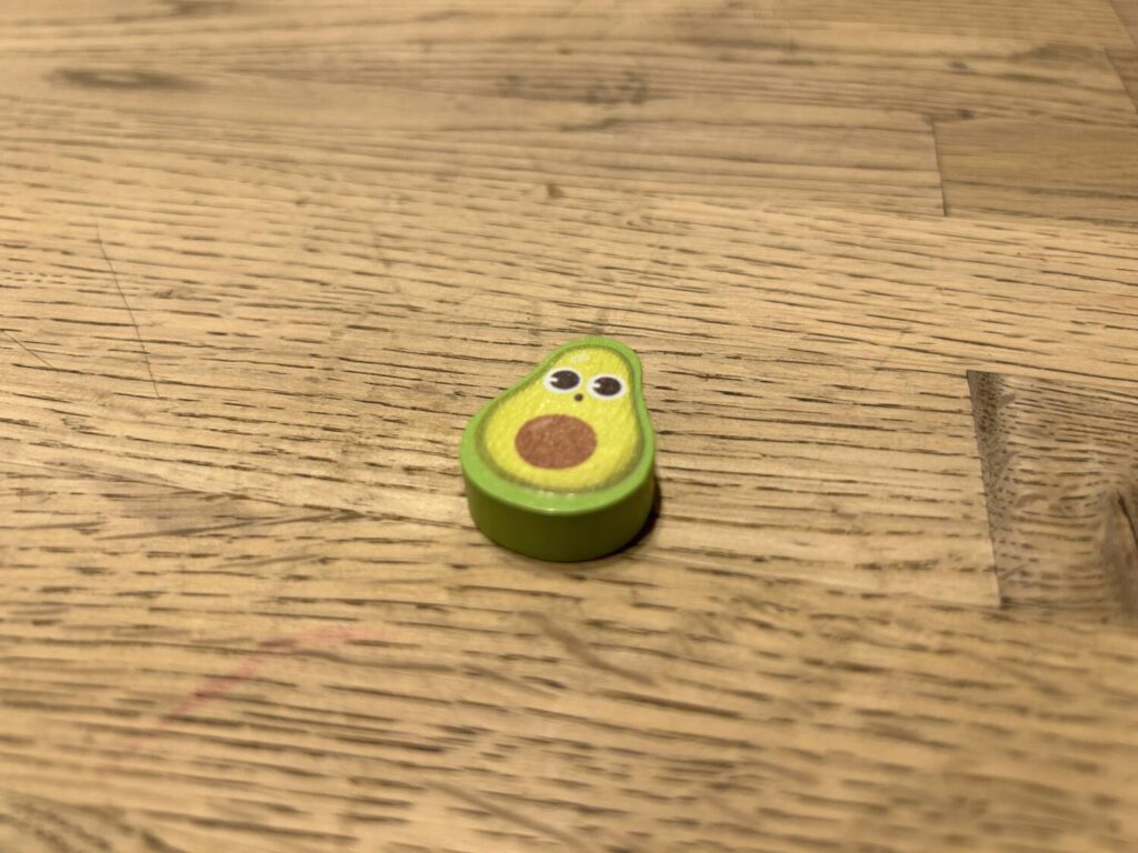 A cute li'l wooden avocado, the first player token.