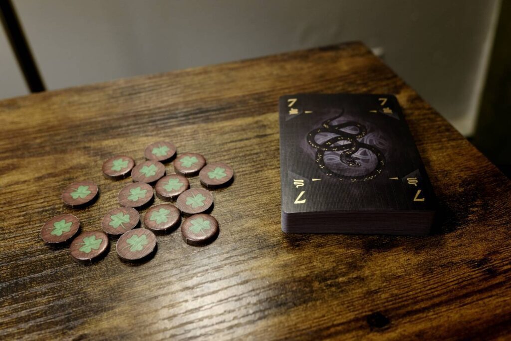 The deck next to a small pile of Relics, small brown cardboard circles with shamrocks on them.