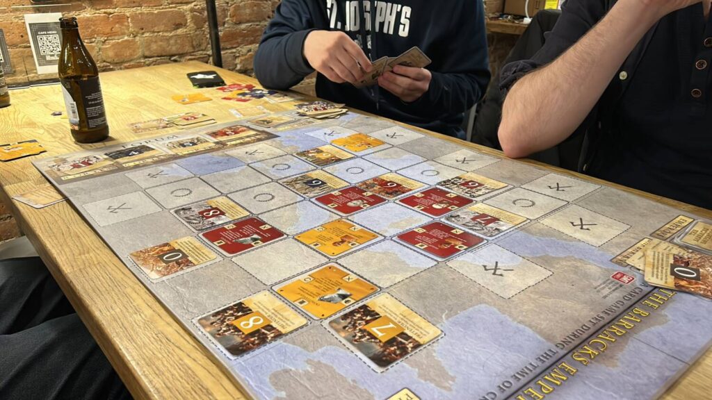 The Barracks Emperor board mid-game. Square cards are laid out on a somewhat irregular grid, with a map of the Mediterranean underneath.