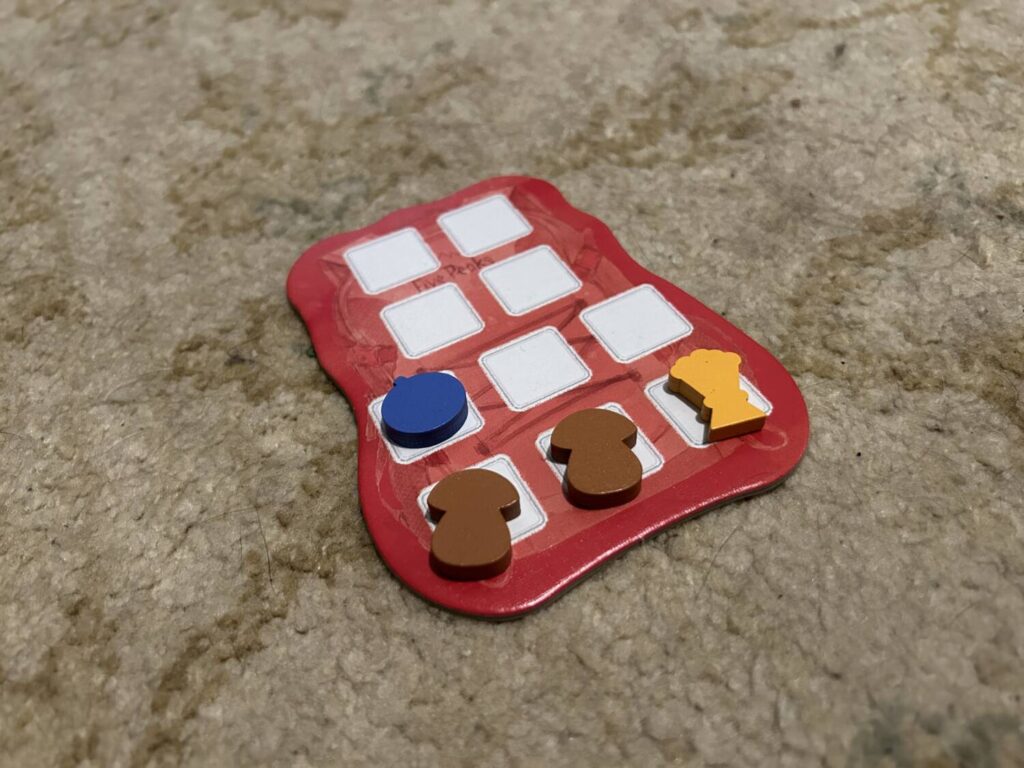 A resource board in the shape of a hiking pack, with ten slots for goods.