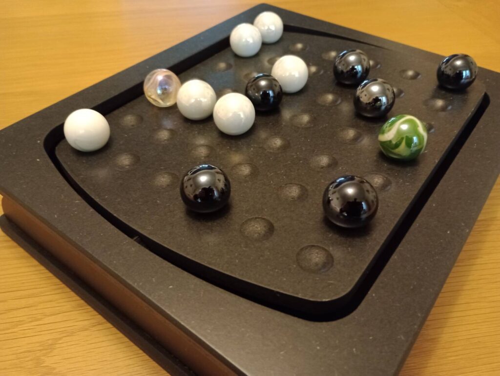 Mid-game and marbles are positioned across the board, which is tilting slightly with the weight distribution of the marbles.