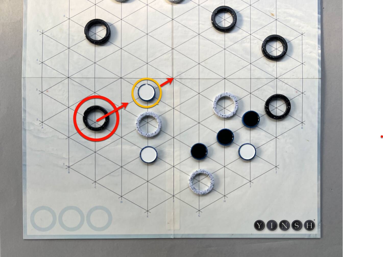 Black takes the Black ring, moving just past the white piece...