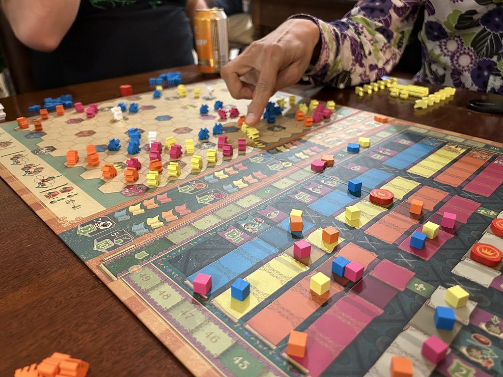 The Cascadero board, about halfway through a game. The left half of the board is a large hexagonal grid. The right side is a series of tracks.