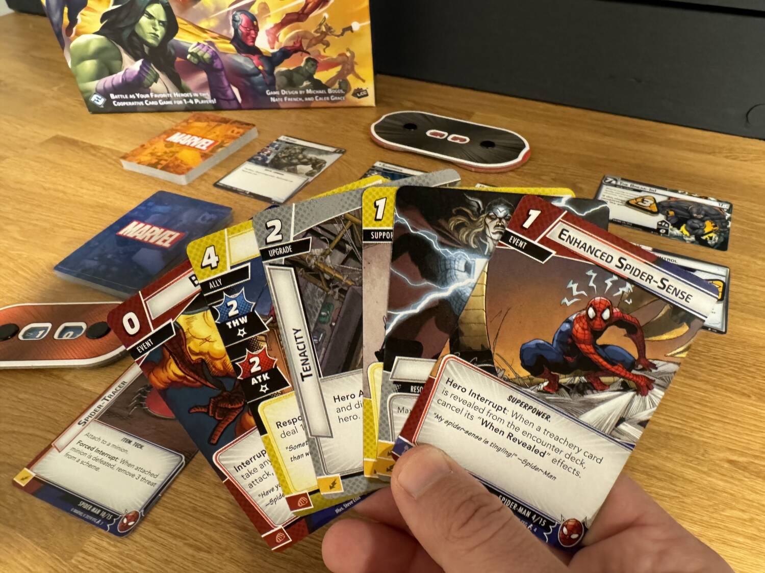 A fan of cards for Marvel Champions: The Card Game, showing Spider-Man's deck with Rhino's scheme cards in the background.