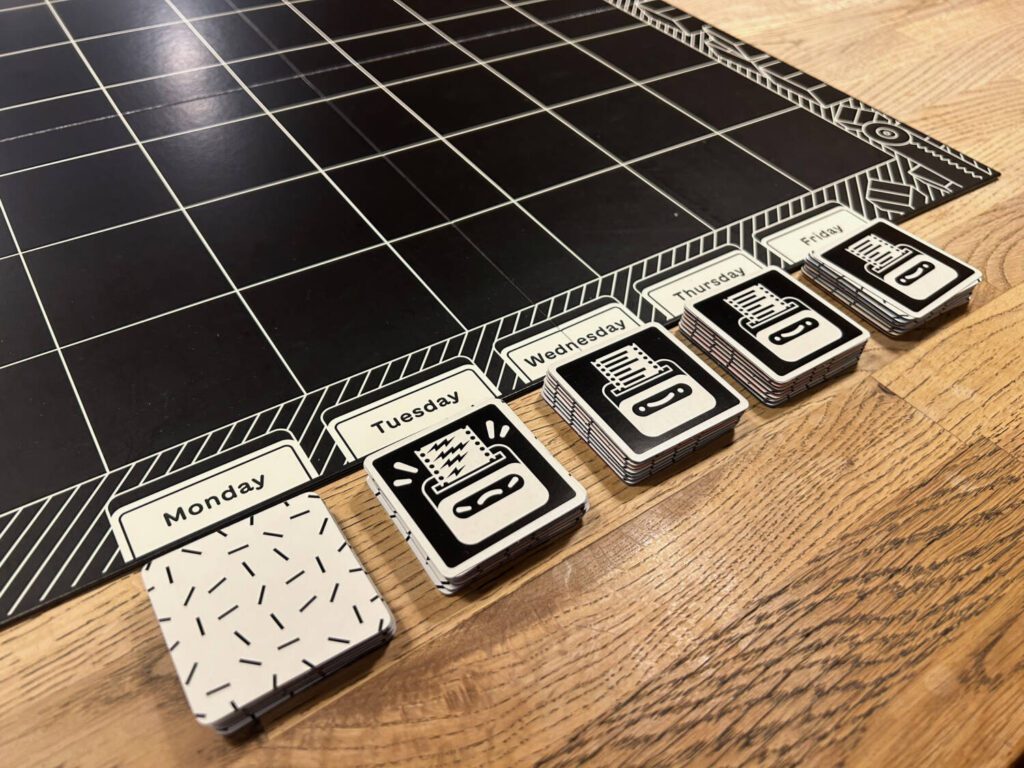 Five stacks of seven tiles with white backs. Four of the stacks have a challenge card on top of them.