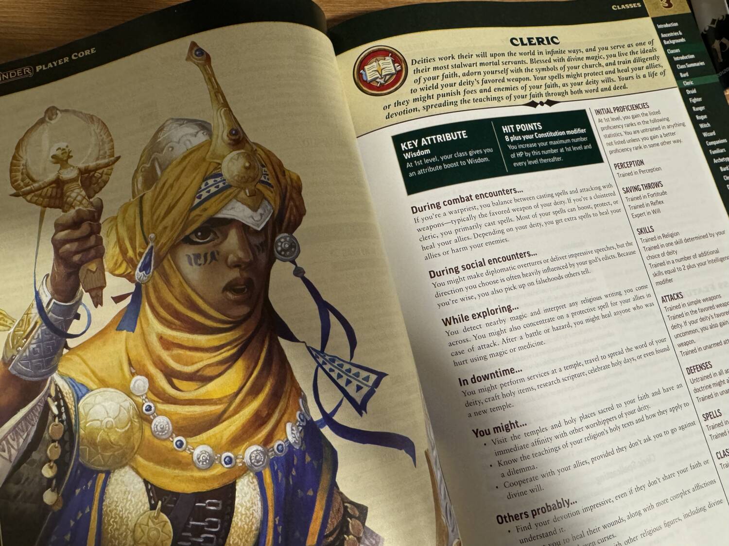 Pathfinder Player Core book open to the page showing Kyra the iconic cleric for Pathfinder Second Edition.