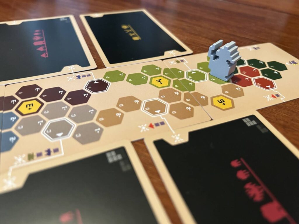 The map for Unreliable Wizard is three cards, each with a series of different-colored hexagons. Each hexagon contains a number, indicating the amount of health it costs to move into that space. The wizard is a pixelated wooden figure.