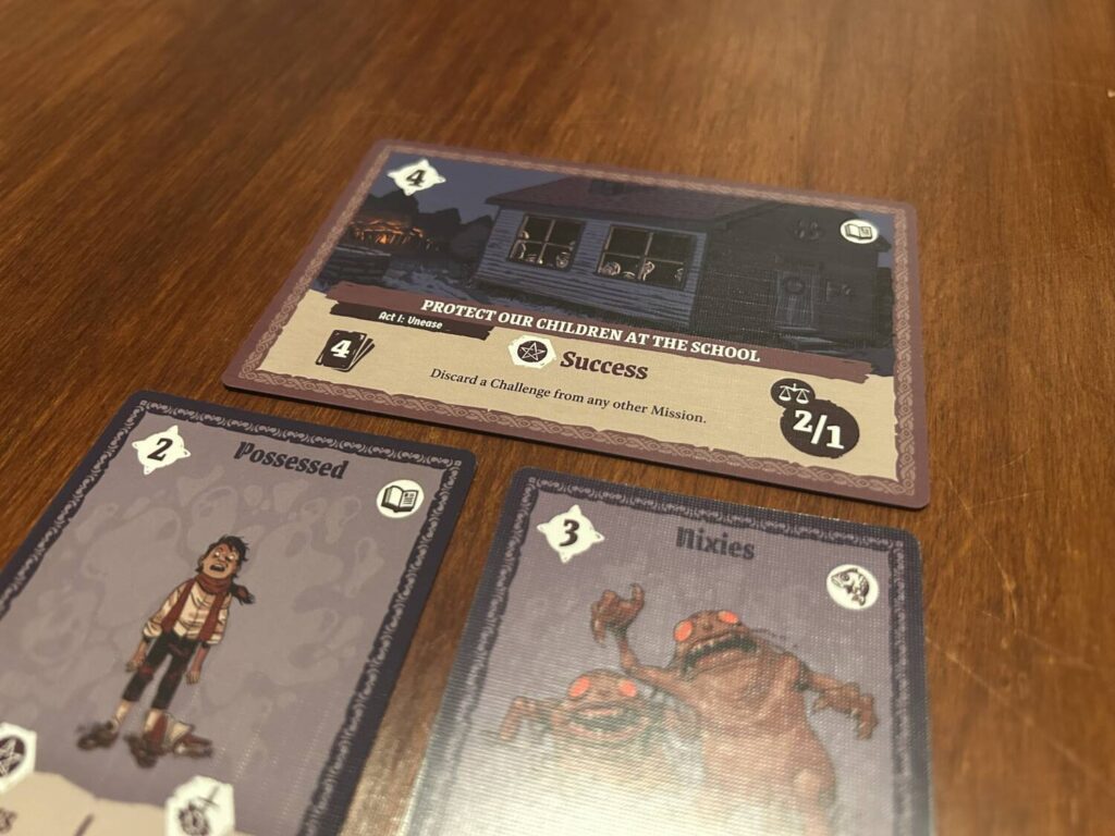 A close up photo of a single mission. The card includes a wide-format illustration, specifies a number of Challenge cards to be included, and spells out any perks or consequences associated with the mission.