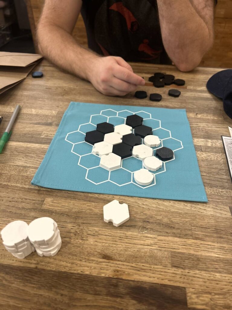 A game of Xok close to the end. Two large clusters of white site next to two smaller clusters of black pieces.