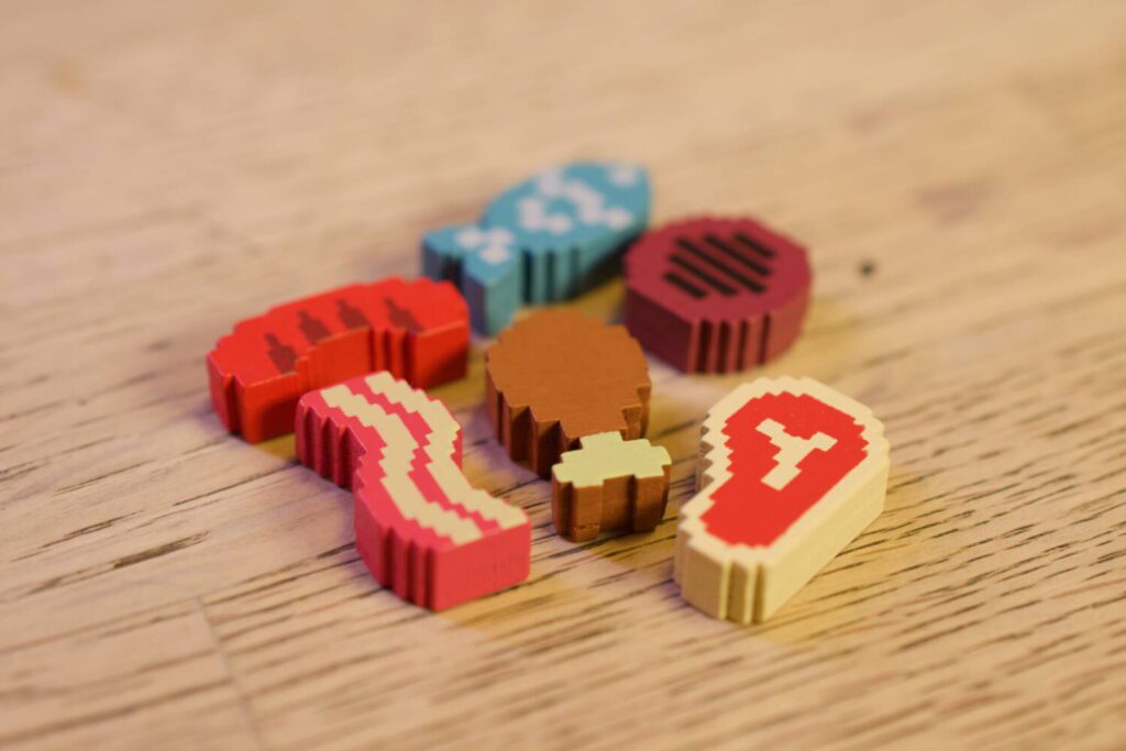 A close-up photo of all six food stuffs: sausage, fish, burger, steak, chicken leg, and bacon.