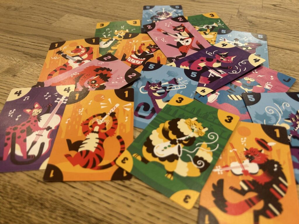 The 16 different cat illustrations in a disheveled pile. The cards are boldly colored.