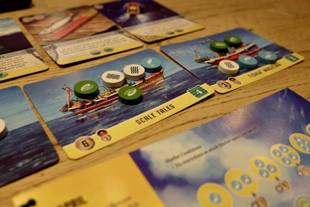 Fishing boat cards with the tokens that represent their hauls.