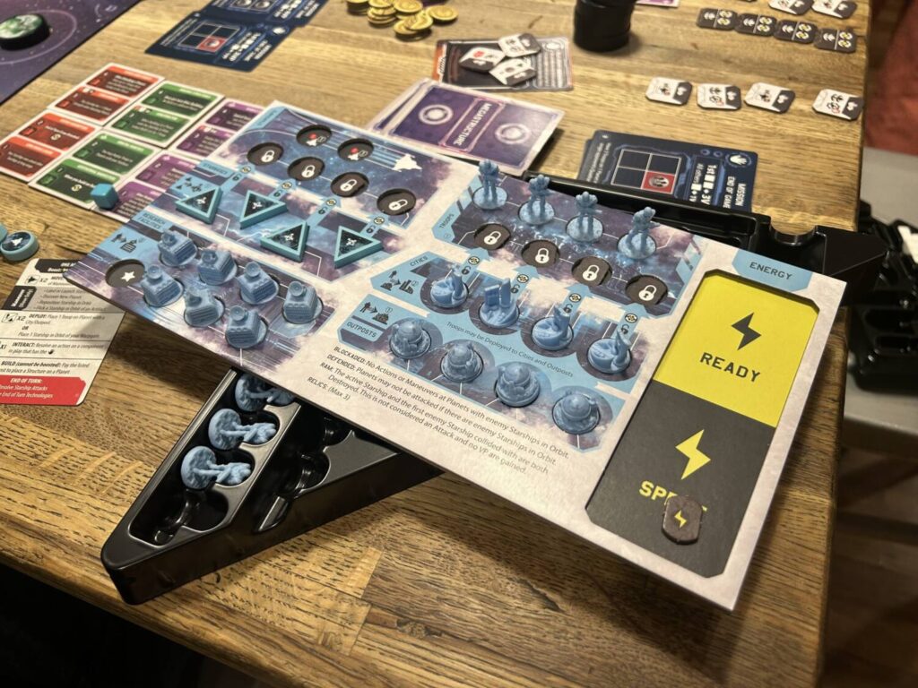 A rectangular dual-layer player board, loaded up with miniatures for various structures and troops.