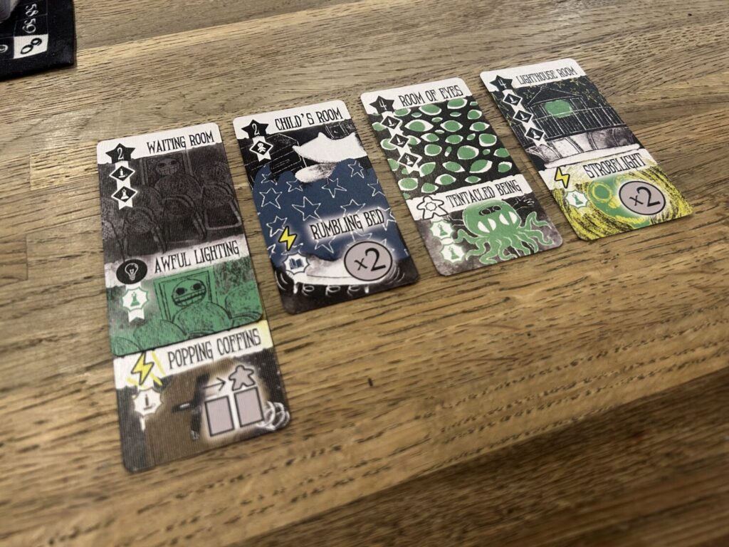 Four Scene cards in a row, labelled Waiting Room, Child's Room, Room of Eyes, and Lighthouse Room. The Waiting Room has a Popping Coffins card tucked underneath.