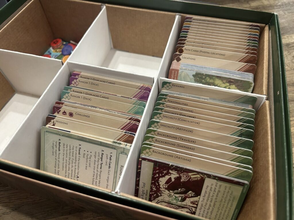 A medium-sized box, subdivided into six sections. Three of the sections are full of cardboard tabs that separate various sets of cards.