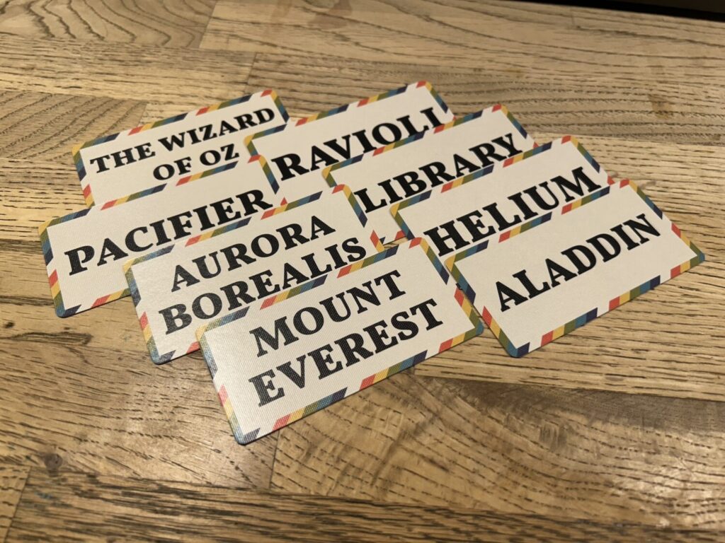 A group of eight cards sitting on a wooden table.