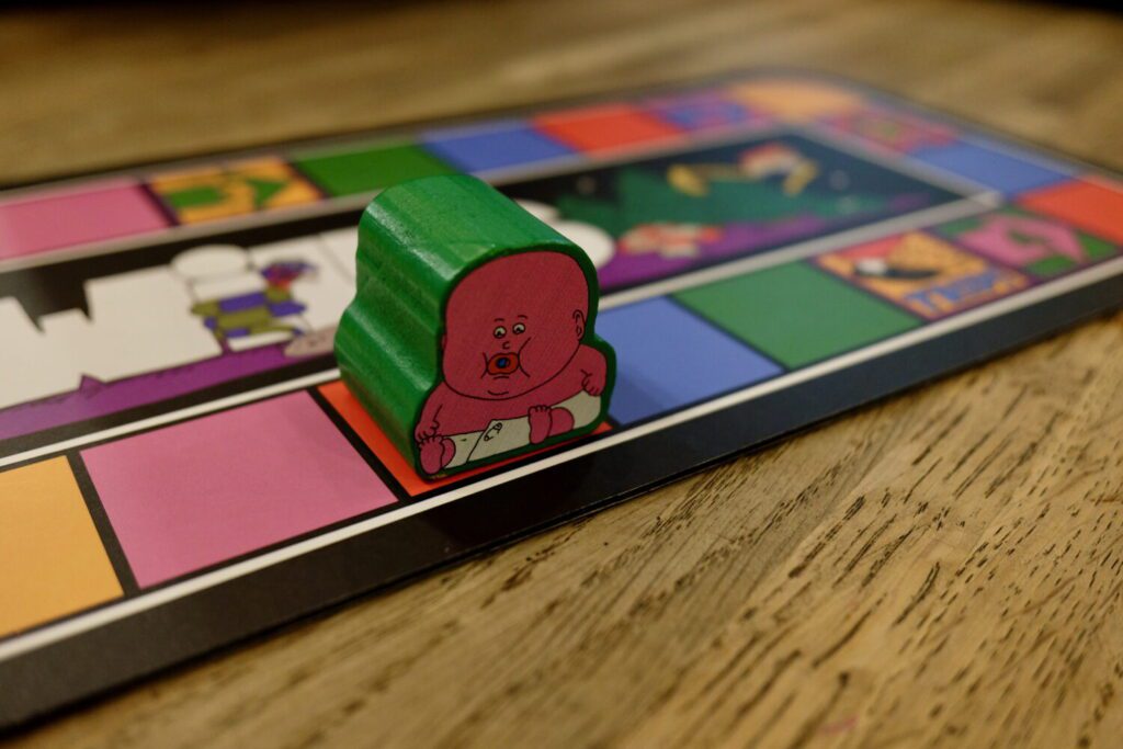 Big Baby, an extra-thick wooden figure illustrated as a giant pink baby, sits on the player board. He takes up an entire square of the board.