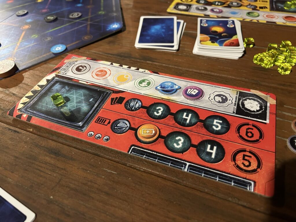 A red player board, used to track upgrades and available cubes, sits on a wooden table.
