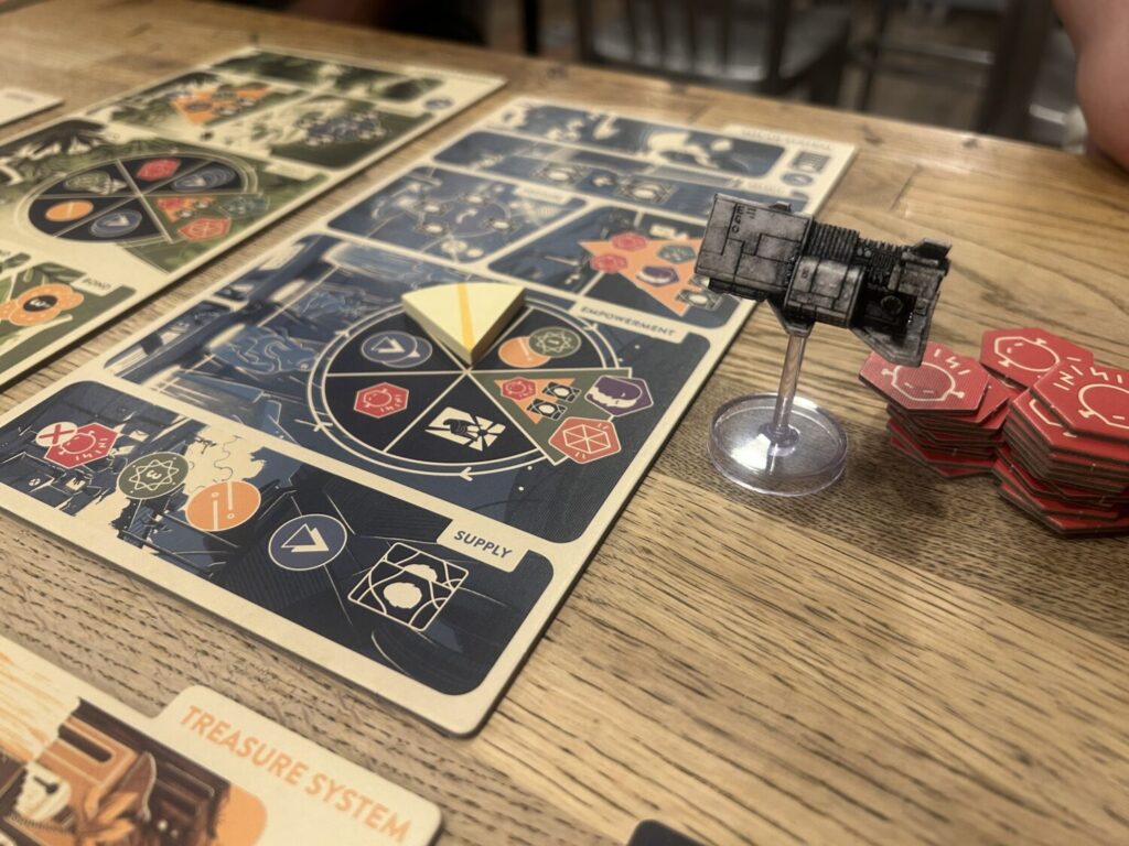 A close up photograph of one board on a wooden table. It is divided into oddly-shaped sections, each corresponding to a specific event.