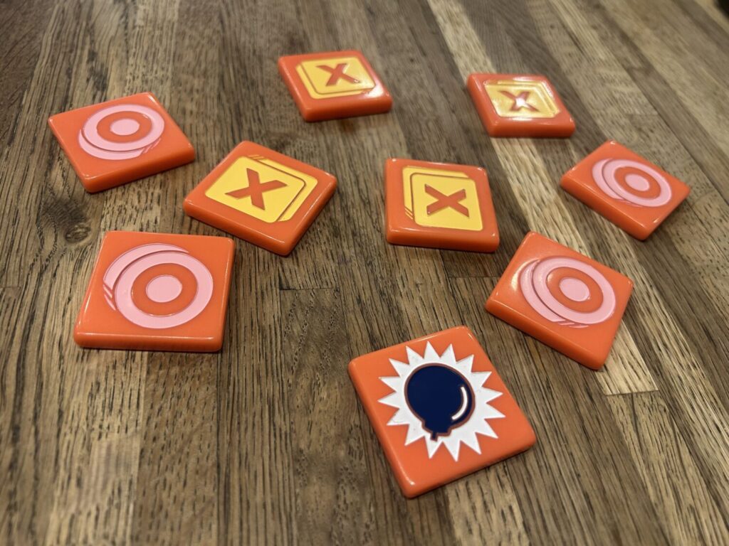 A collection of nine orange bakelite tiles on a wooden table.