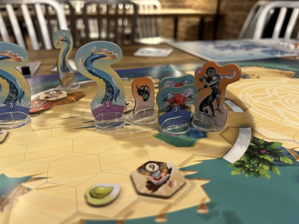 The same board as before, but now with extra monster tentacle standees. All character illustrations are in bold colors.