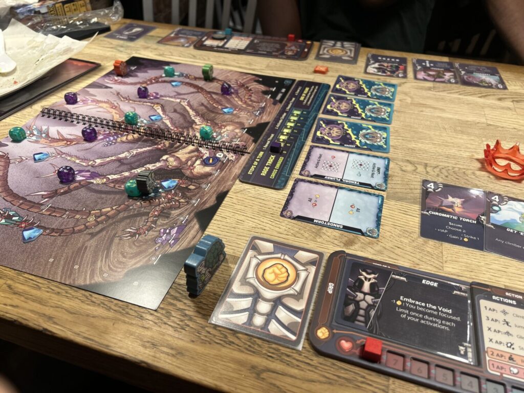 A game of Leviathan Wilds in progress. A booklet sits to the left of the table, with player boards to the right.