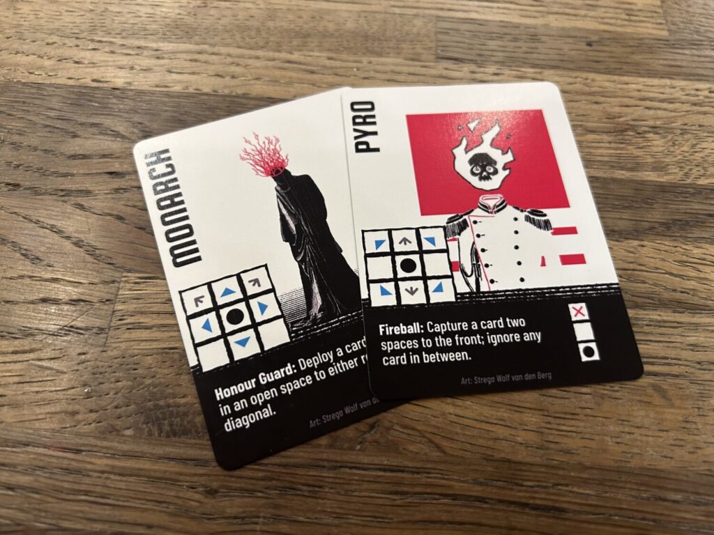 Two cards on a wooden table. This time, the cards are shown with the opposite side up, with a white background and black text box.