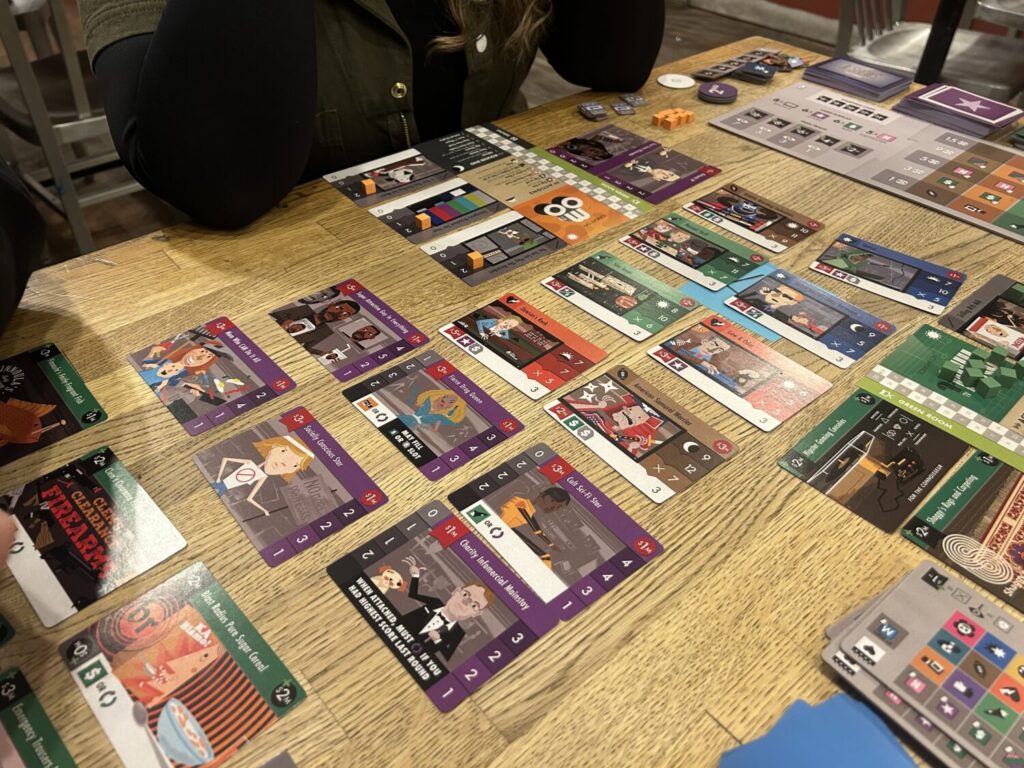 A table jam-packed with cards, each bearing humorous illustrations of actors, sets, and television programs.