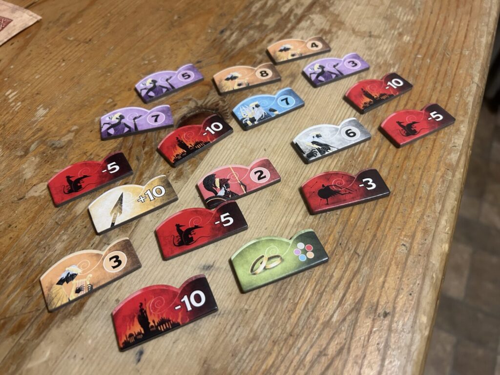 A selection of scoring tiles laid out on a wooden table.