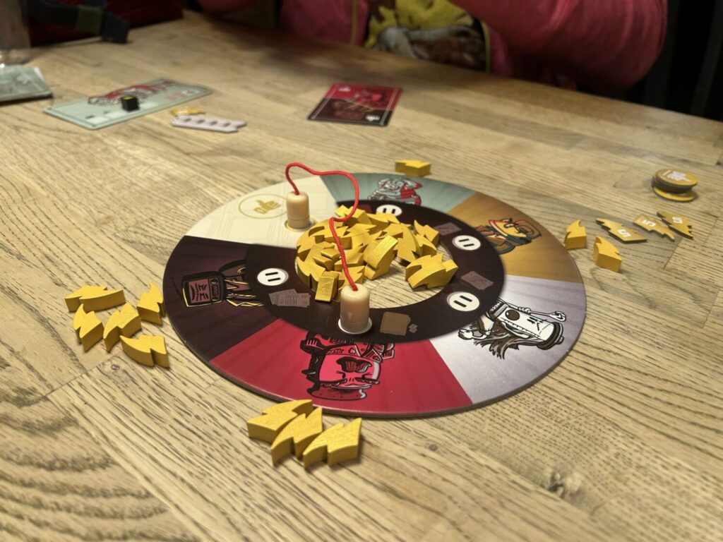 A circular board with a hole in the middle, filled with lightning-shaped power tokens.