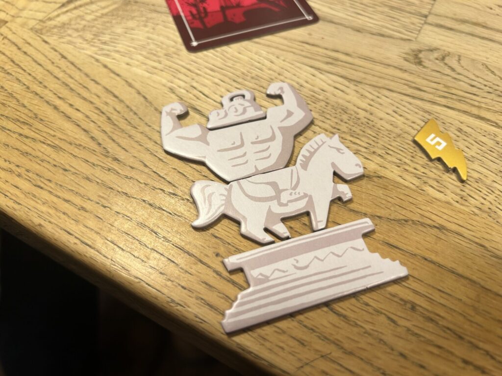 A statue made of four different pieces, depicting a buff man riding atop a horse. The man's head is an iron.