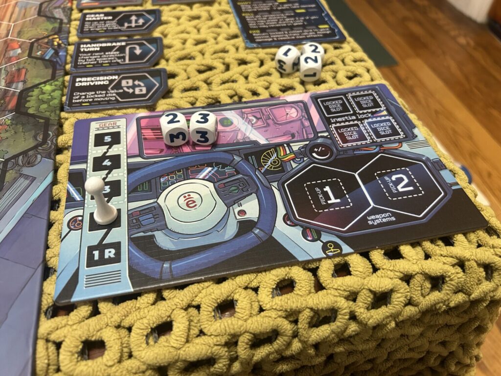 A player dashboard, a flat card with gear shift panels to the left and several slots for dice. The illustration is humorous. Three robotic faces can be seen in the rearview mirror.