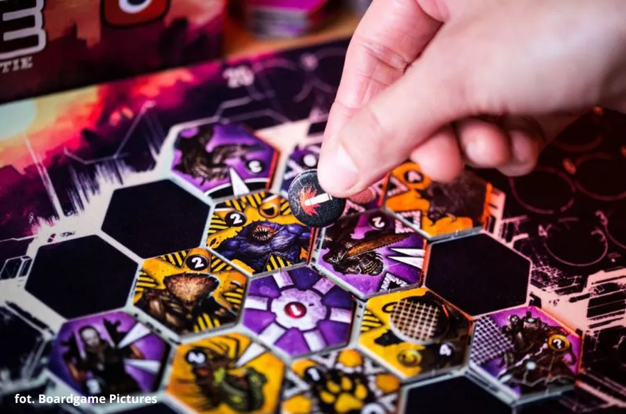A hand places a wound token onto a Unit on the board.