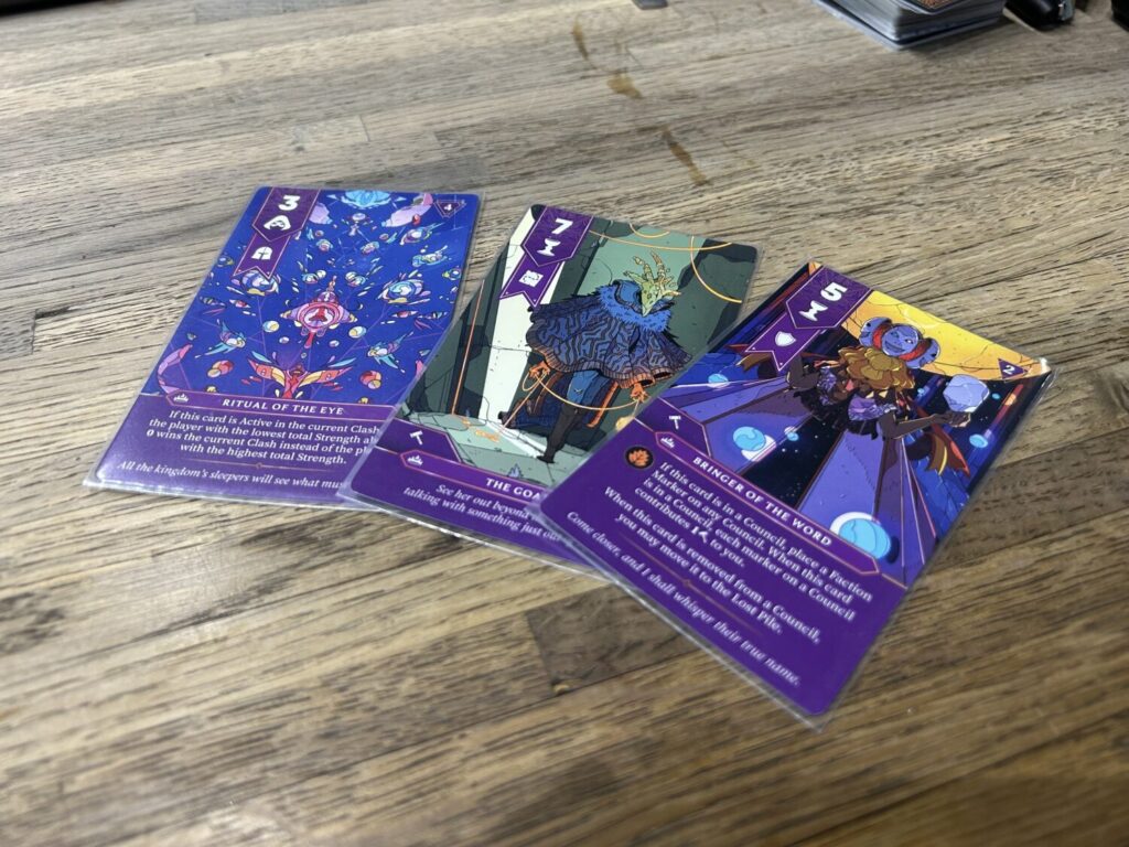 Three of the Gathering's player cards, each with an astonishing full-color illustration taking up the bulk of the card.