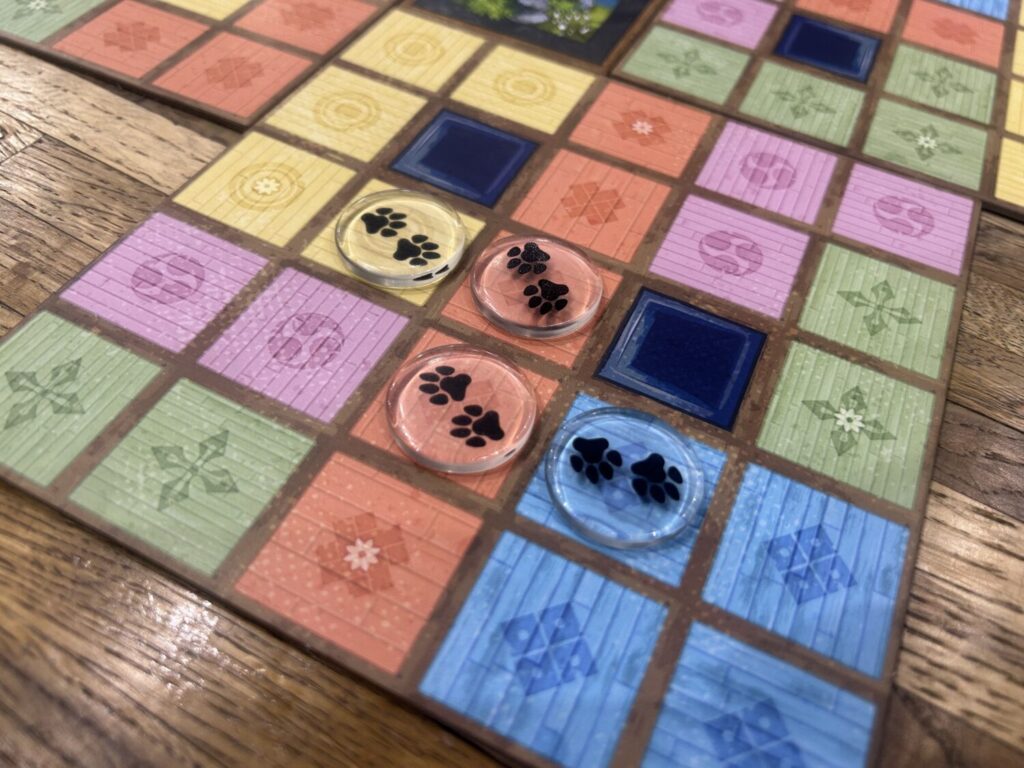 Four clear plastic circles with black pawprints on them sit on squares in a grid.