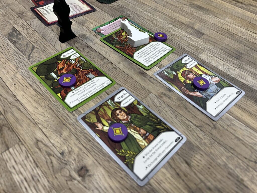 Four character cards sit on the table, ripe for the choosing before starting a hand. Each card includes a stained glass style portrait and a challenge at the bottom of the card.